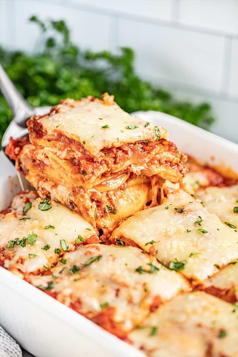 A spatula holding up a piece of ravioli lasagna.