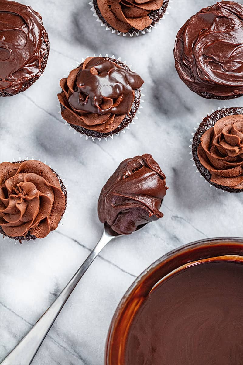 An overhead view of chocolate cupcakes with chocolate ganache.