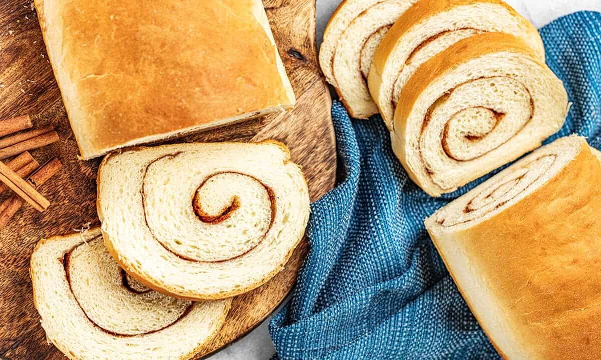 Overhead view of a loaf of bread cut into slices with a swirl of cinnamon sugar throughout.