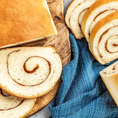 Overhead view of a loaf of bread cut into slices with a swirl of cinnamon sugar throughout.