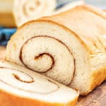 A loaf of cinnamon swirl bread with a slice cut off.