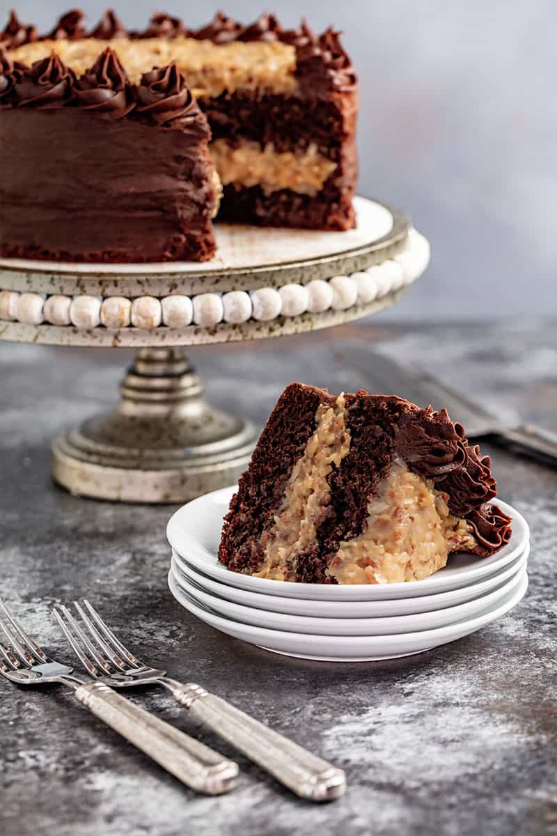 A slice of German Chocolate Cake on a stack of plates.