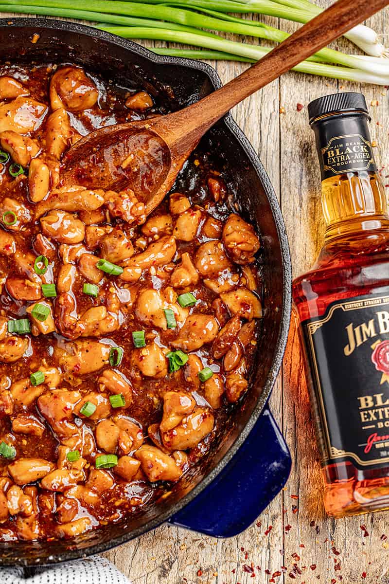 A skillet filled with saucy bourbon chicken.