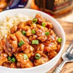 A bowl filled with saucy bourbon chicken and rice.