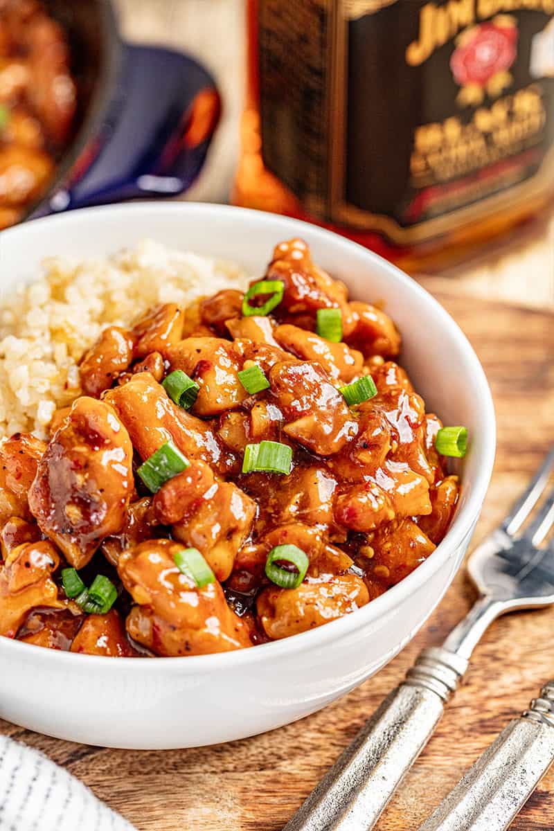 A bowl filled with saucy bourbon chicken and rice.