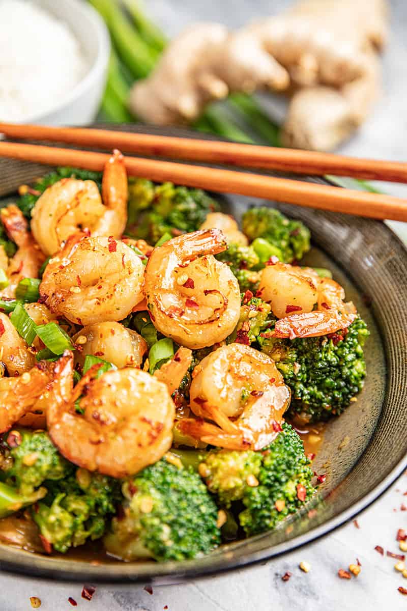 Spicy szechuan shrimp and broccoli with chopsticks.