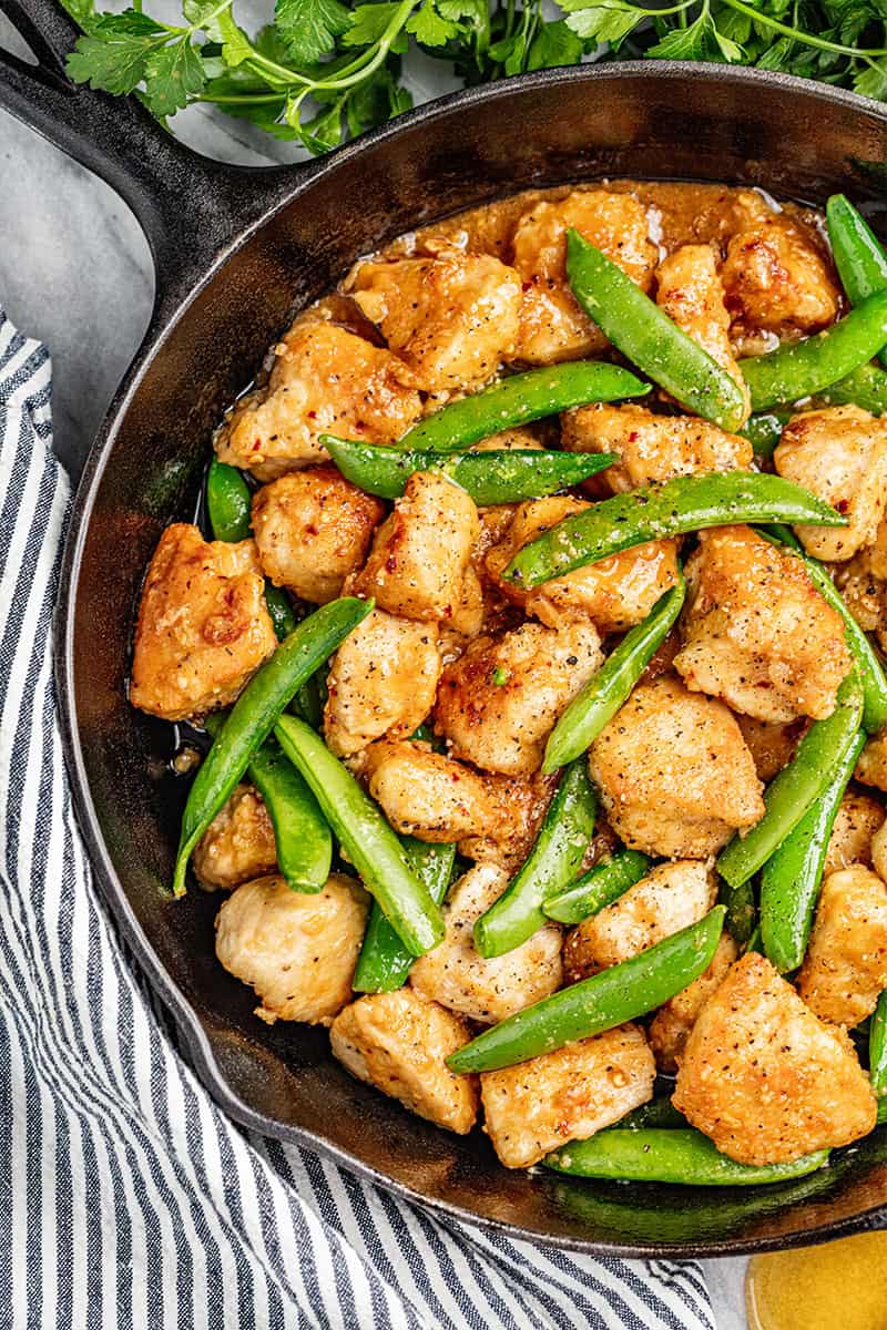 Overhead view of sticky honey garlic chicken and snap peas.