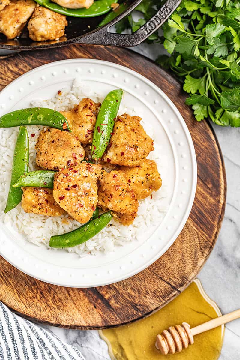 Overhead view of a dinner plate with sticky honey garlic snap peas and rice.