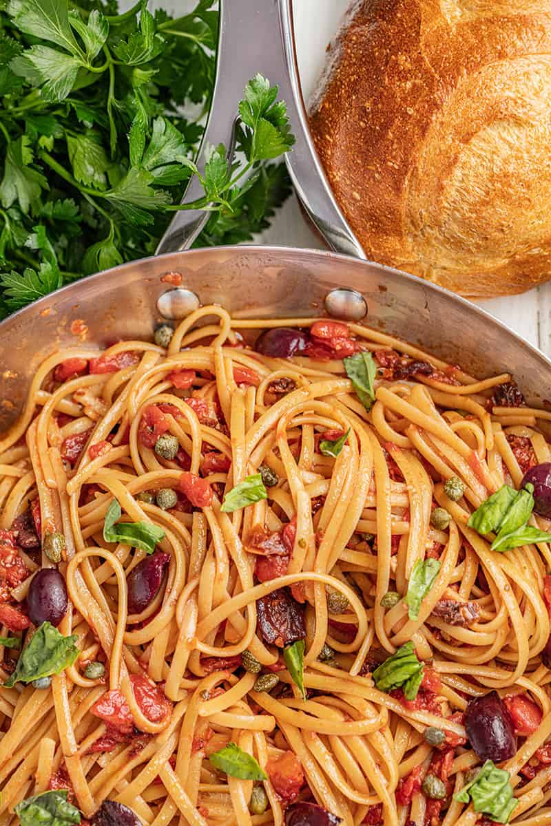 Pasta puttanesca with olives and basil.