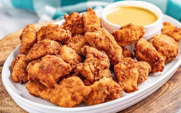 Copycat Chick Fil-A nuggets on a serving platter with dipping sauce.