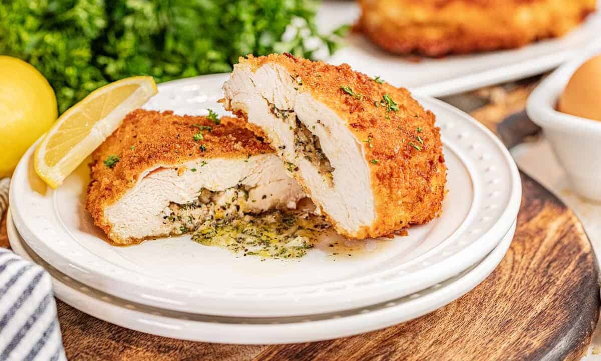 Chicken Kiev cut in half with compound butter spilling out.