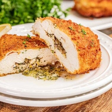 Chicken Kiev cut in half with compound butter spilling out.