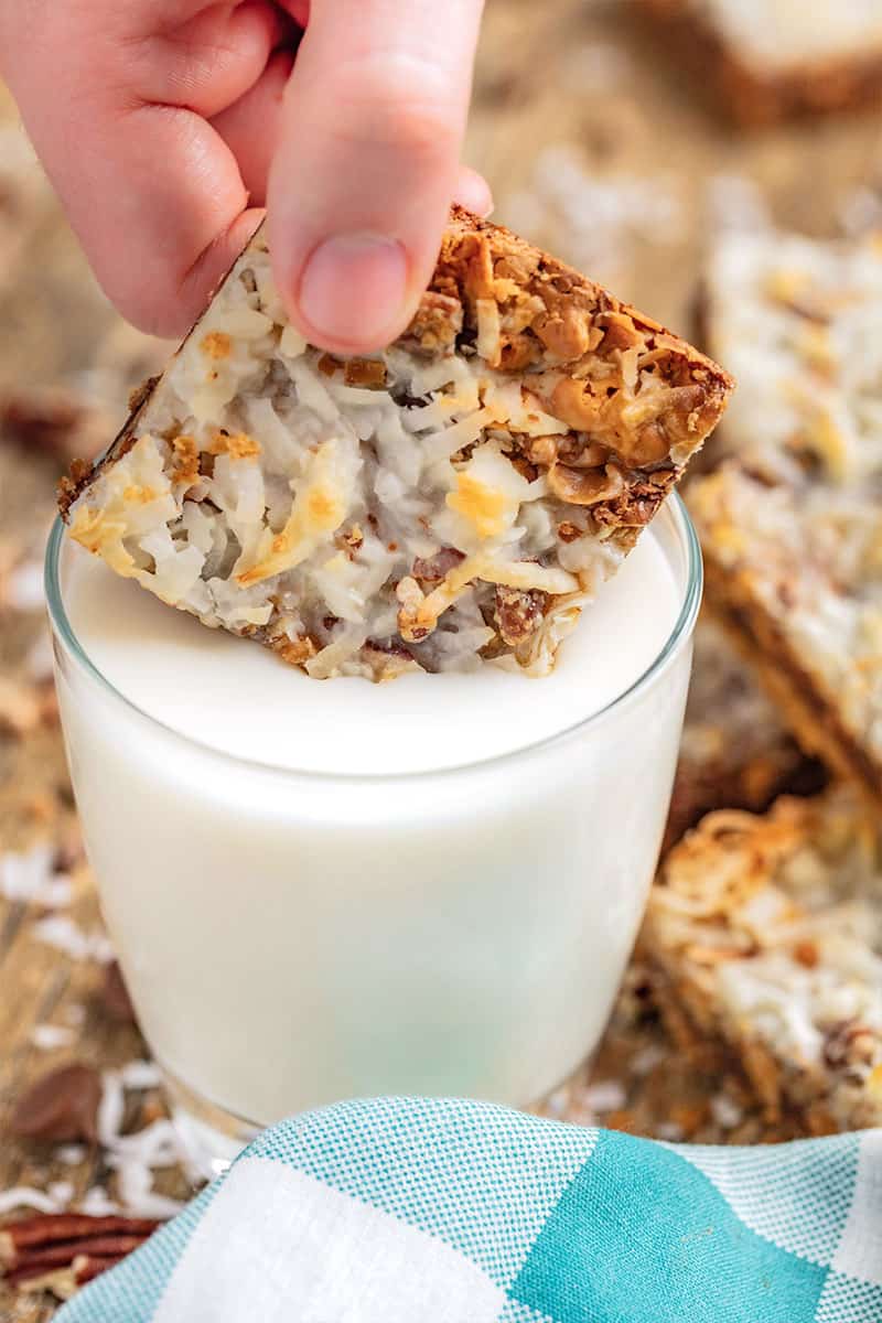 7 Layer Bar being dipped into a cup of milk.