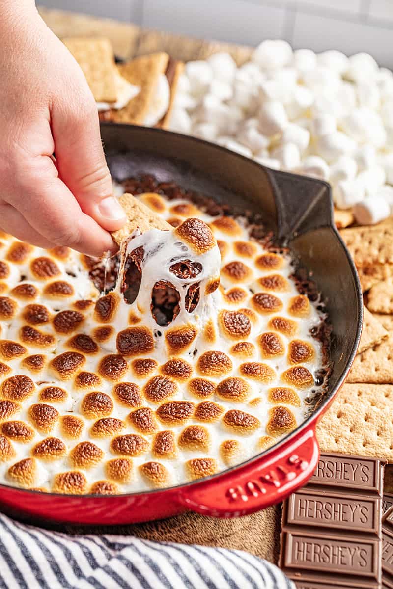 Dip a graham cracker in a baking dish with a simple s'mores dip.