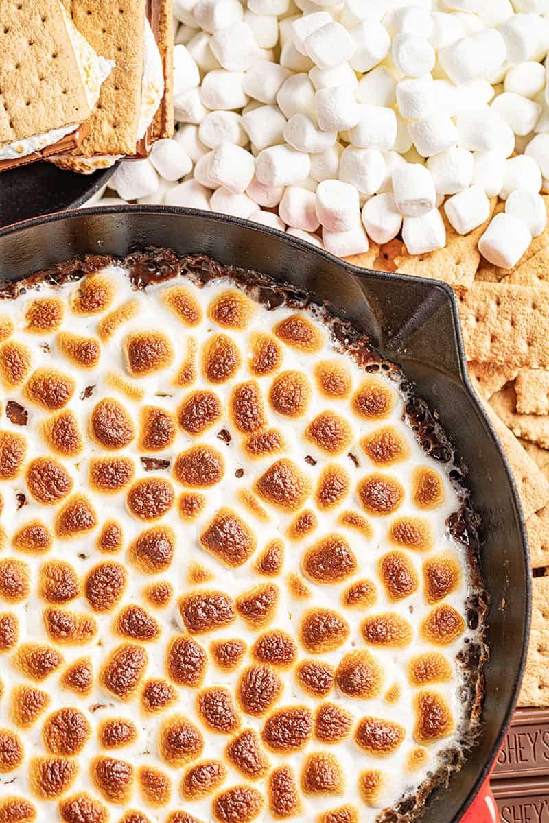 S'mores dip with marshmallows, graham crackers and chocolate nearby.