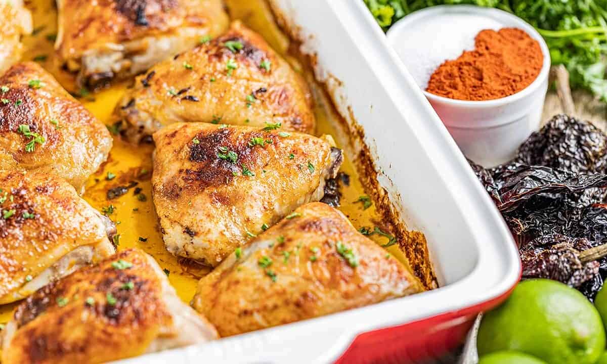 Chipotle and lime chicken thighs in a baking dish.
