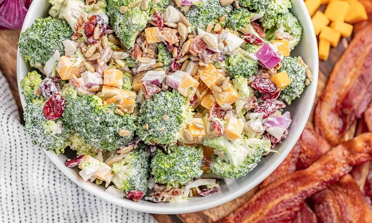 Overhead view of a large white bowl filled with classic broccoli salad.