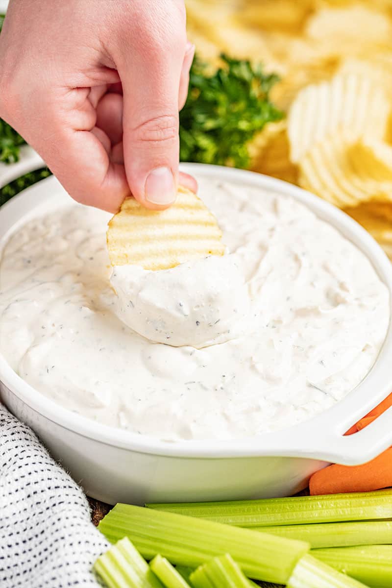 Dipping a potato chip into creamy French onion dip.