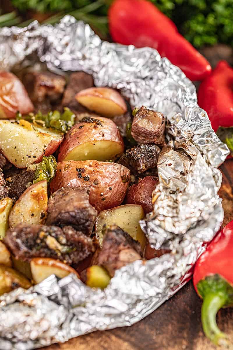 Close up view of a steak and potato foil packet.