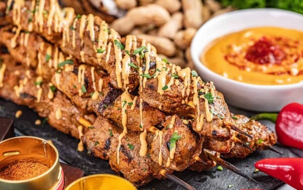 Beef satay with peanut sauce drizzled on top.