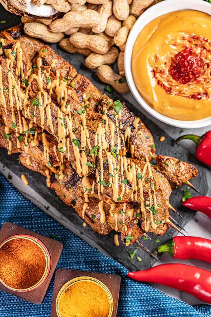 Overhead view of beef satay with peanut sauce.