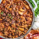 Overhead view of country style baked beans in a saucepan.