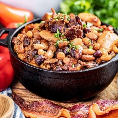 Country style baked beans in a small black bowl.