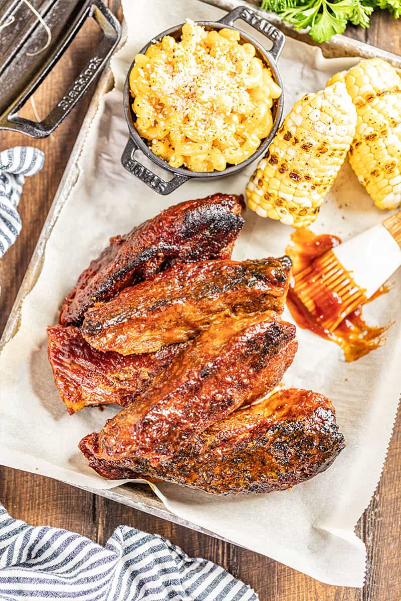 Overhead view of country style pork ribs with grilled corn and Mac and cheese.