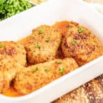 A baking dish filled with crispy breaded pork chops.