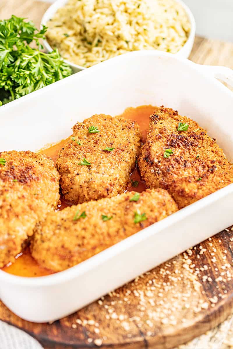 A baking dish filled with crispy breaded pork chops.