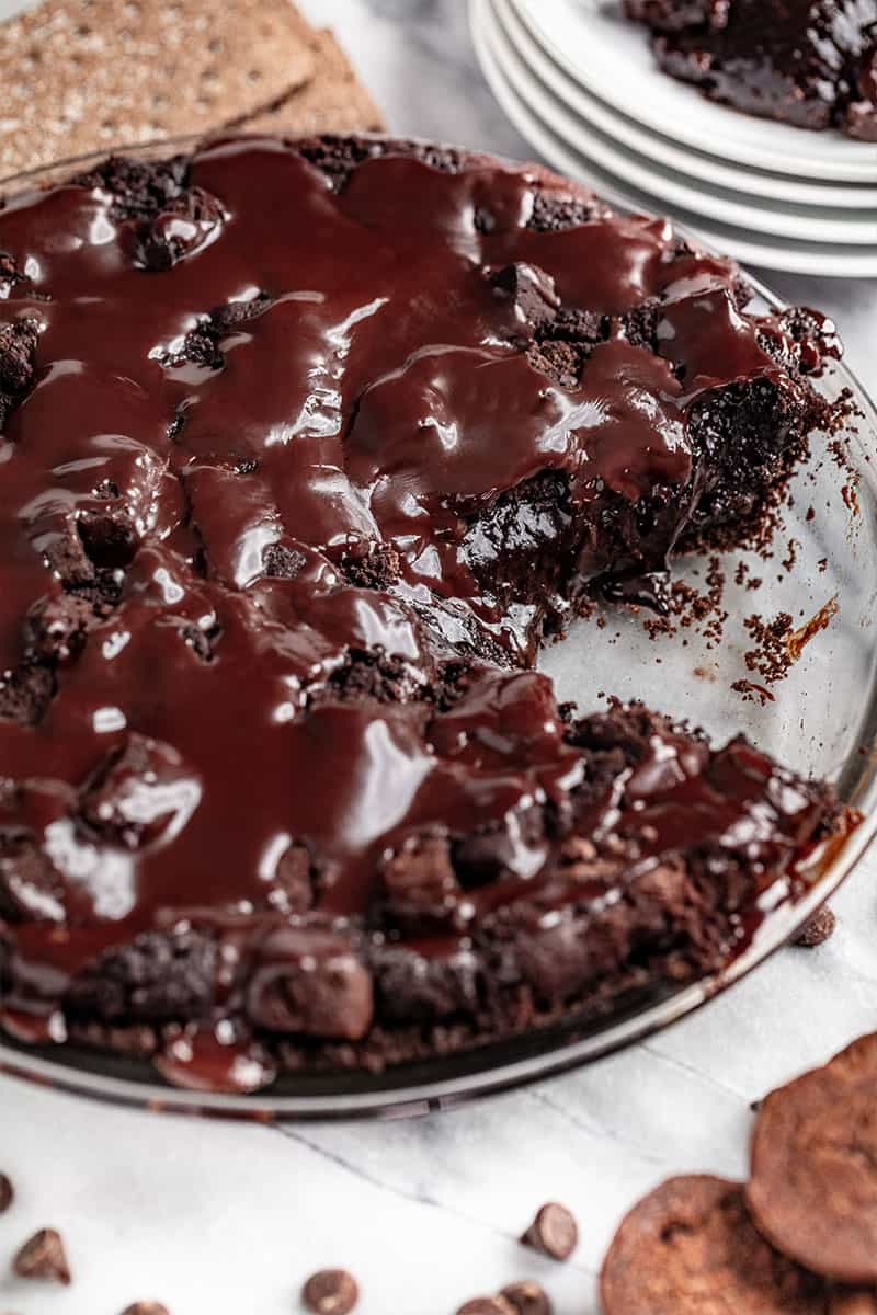 A Mississippi mud pie in a glass pie dish with a slice removed.