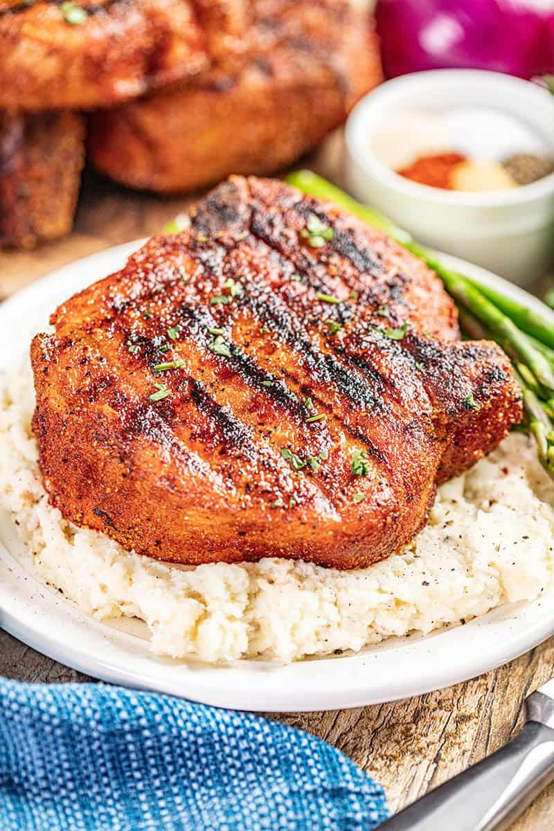 A smoked pork chop and mashed potatoes on a plate.