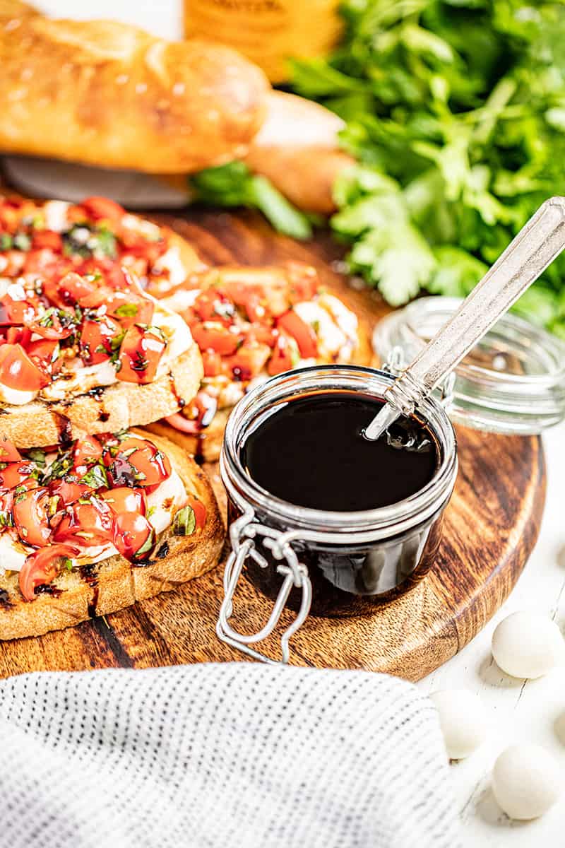 Balsamic glaze with a spoon in the glass.