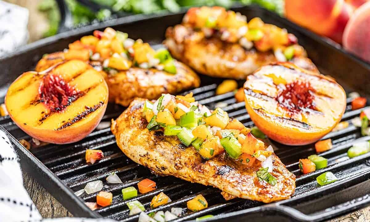 Chipotle peach glazed grilled chicken breasts on a grill pan.