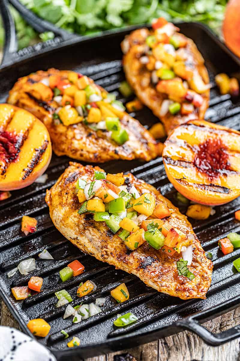 Chipotle peach glazed grilled chicken breasts on a pan.