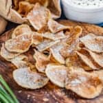 Homemade kettle chips laying out of a paper bag,