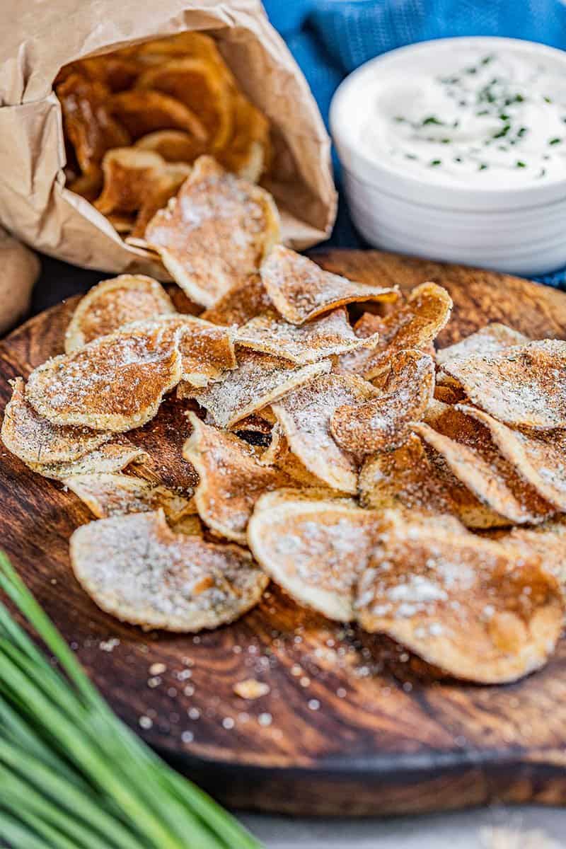 Homemade kettle chips laying out of a paper bag,