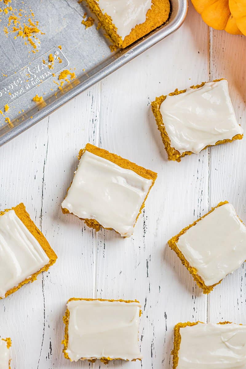 Overhead view of pumpkin bars on a wooden counter.