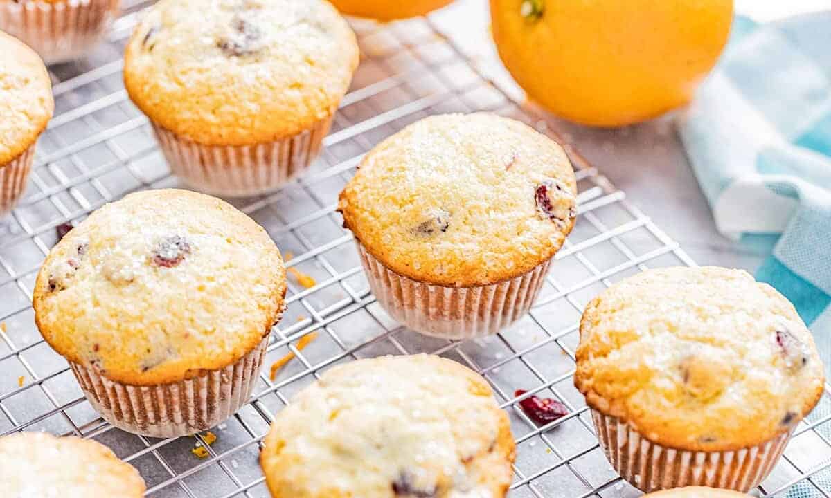 Orange cranberry muffins on a cooling rack.