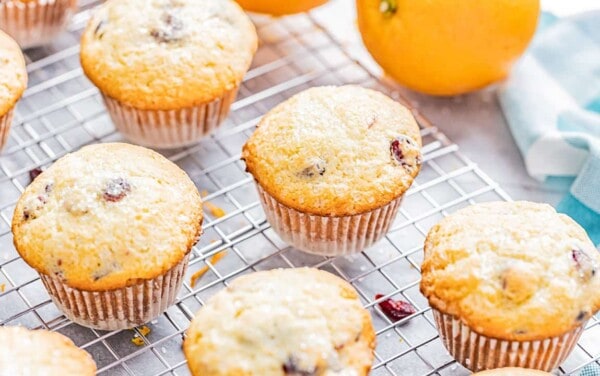 Orange cranberry muffins on a cooling rack.