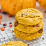 Close up view of a stack of pumpkin chocolate chip cookies on a cooling rack.