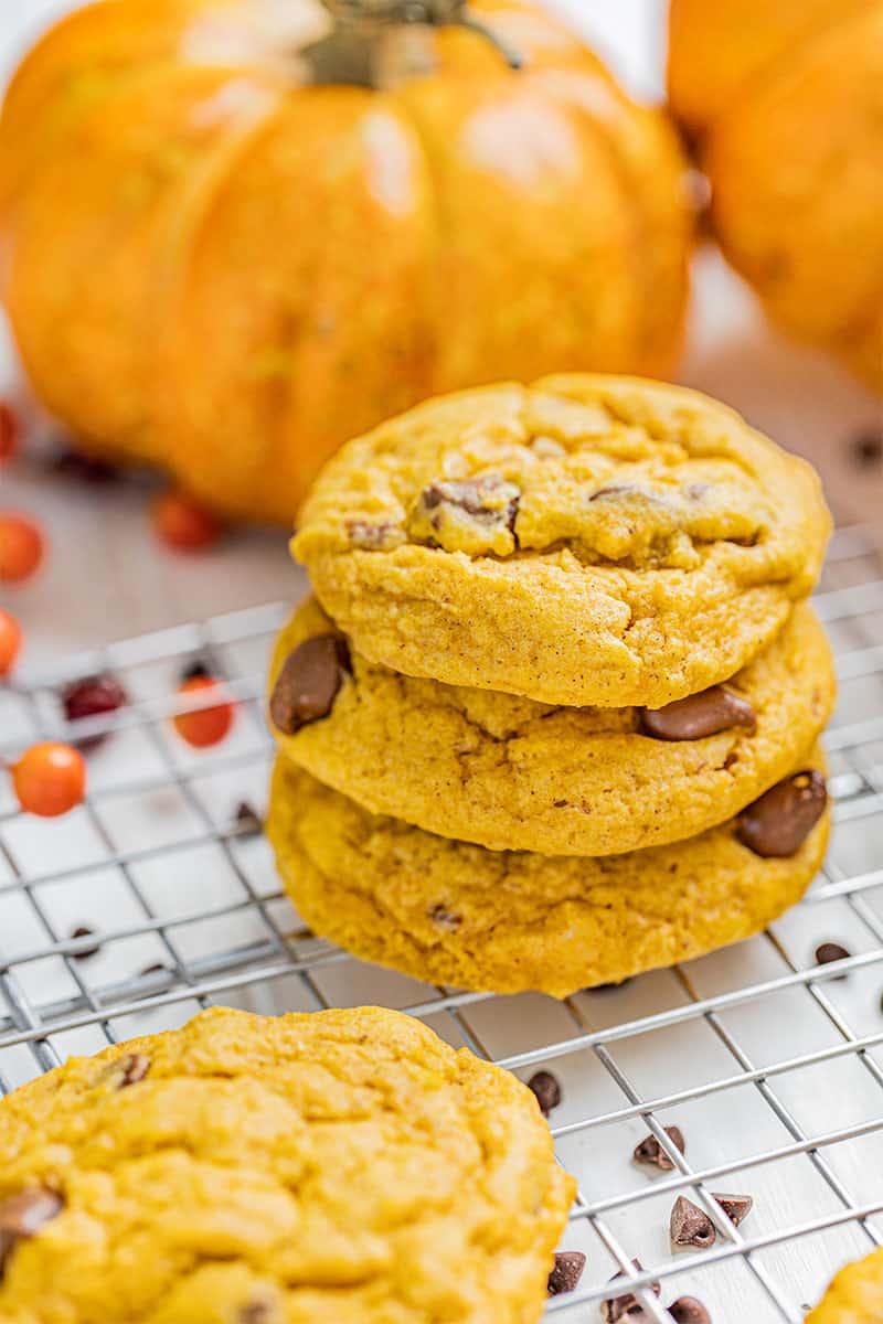 Close up view of a stack of pumpkin chocolate chip cookies on a cooling rack.