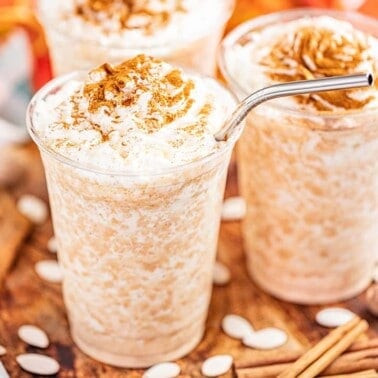 Close up view of pumpkin spice frappes with whipped cream and cinnamon on top.