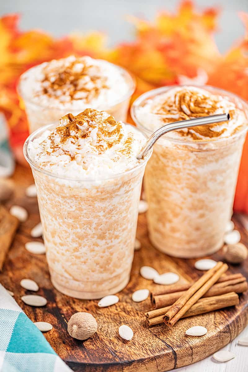 Pumpkin spice frappes with metal straws.