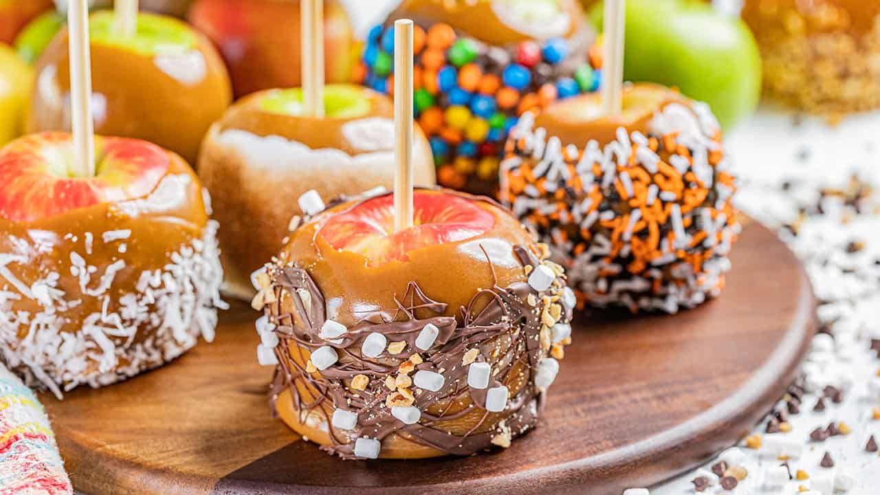 Close up view of caramel apples with various toppings.