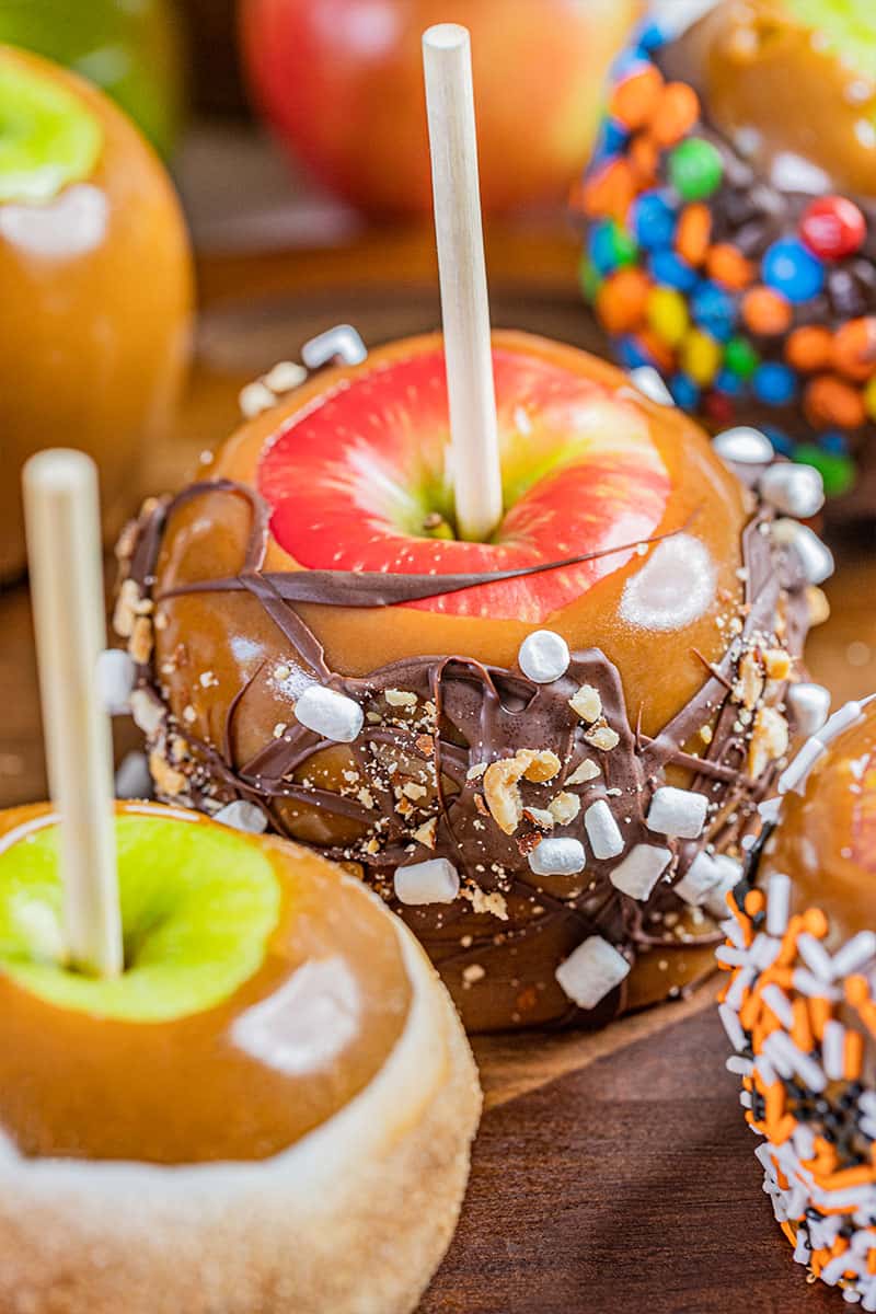 Homemade caramel apples with various toppings.