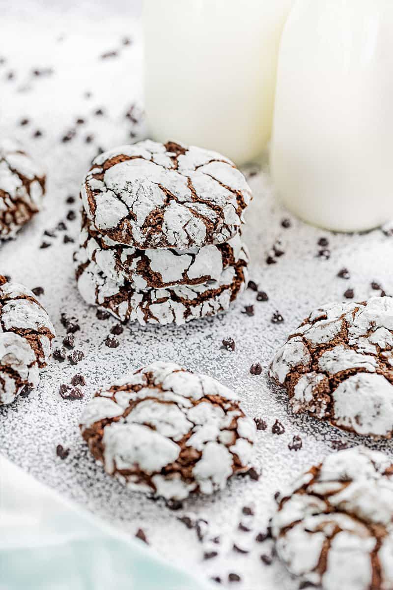 Chocolate crinkle cookies next to jugs of milk.