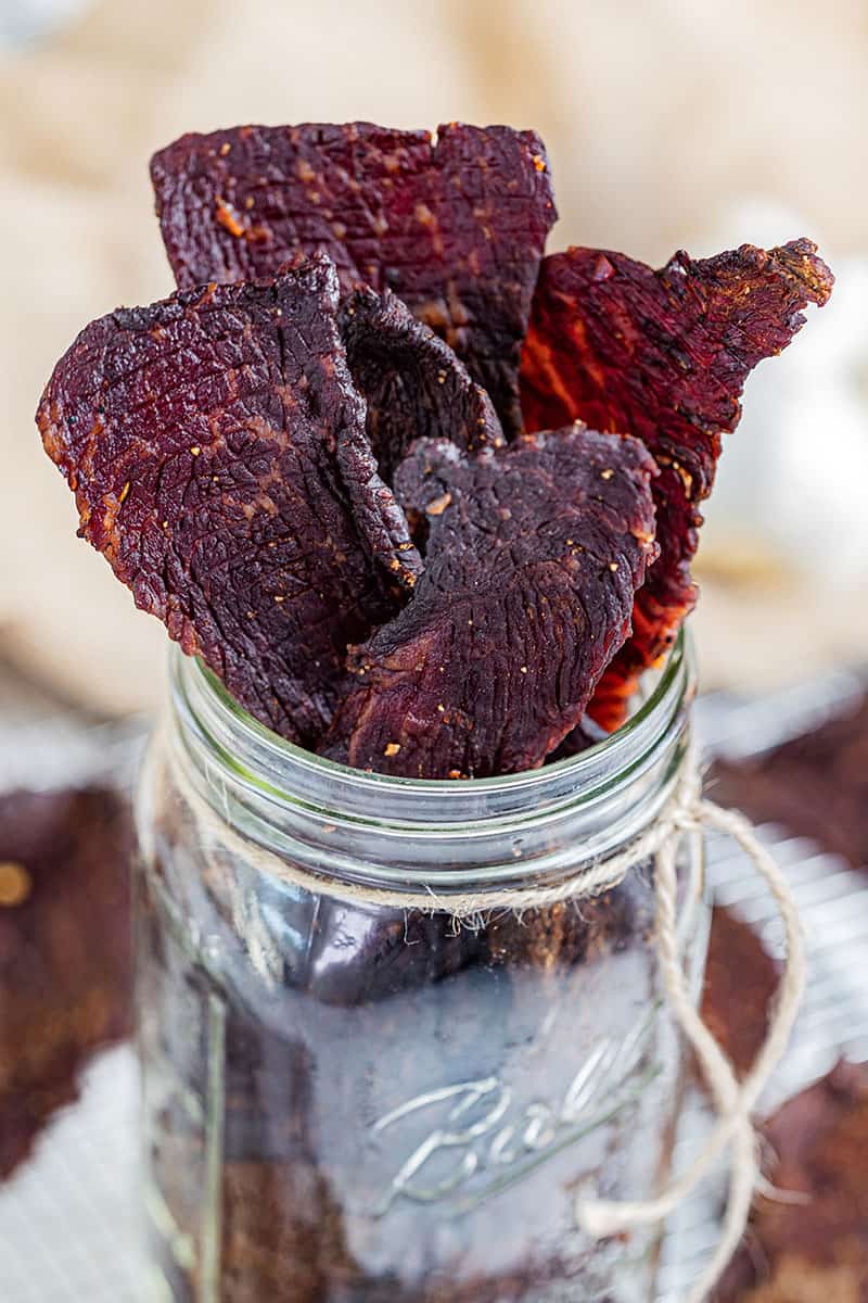 Homemade beef jerky in a glass jar.