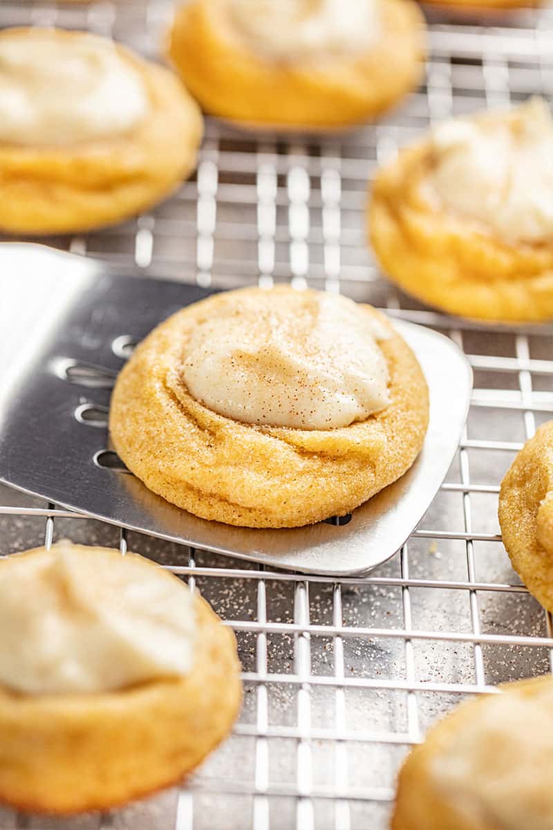 A pumpkin cheesecake thumbprint cookie on a spatula.