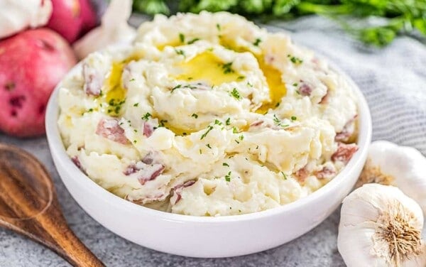 Steakhouse style garlic mashed potatoes in a white bowl.